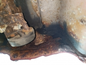 The rear panel of a Toyota Camry v40 is red and rusty, with a broken stud.
