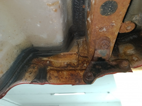 The rear panel of a Toyota Camry v40 is red and rusty, with a broken stud.