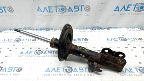 The front left shock absorber of a Toyota Camry V40 hybrid is rusty.