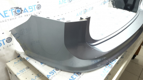 The rear bumper is bare, the upper part is white, the fasteners are cracked.