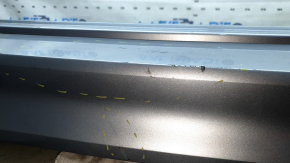 The rear bumper is bare, the upper part is white, the fasteners are cracked.