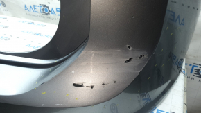 The rear bumper is bare, the upper part is white, the fasteners are cracked.
