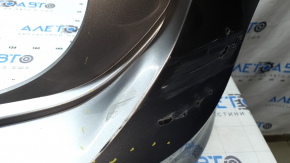 The rear bumper is bare, the upper part is white, the fasteners are cracked.