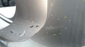 The rear bumper is bare, the upper part is white, the fasteners are cracked.
