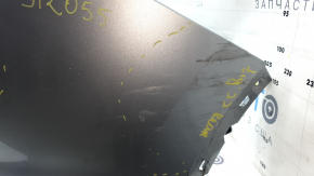 The rear bumper is bare, the upper part is white, the fasteners are cracked.