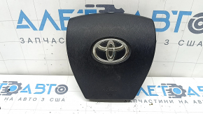 The airbag in the driver's steering wheel of a Toyota Prius 30 10-15 is black, scratched, worn, and the chrome is peeling.