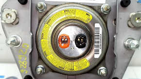 The airbag in the driver's steering wheel of a Toyota Prius 30 10-15 is black, scratched, worn, and the chrome is peeling.