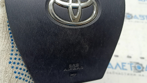 The airbag in the driver's steering wheel of a Toyota Prius 30 10-15 is black, scratched, worn, and the chrome is peeling.