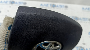 The airbag in the driver's steering wheel of a Toyota Prius 30 10-15 is black, scratched, worn, and the chrome is peeling.