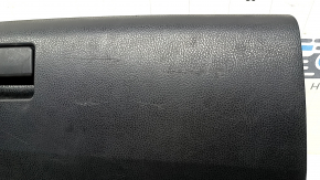 The glove compartment of a Toyota Rav4 2013-2018 is black and has scratches.