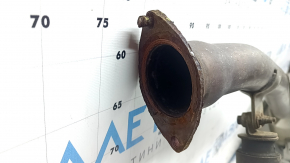 The exhaust pipe, middle section of a 1998 Toyota Rav4 hybrid, is rusty, dented, and has a broken stud.