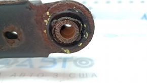 The lower control arm under the rear left spring of a Toyota Rav4 15-18 is rusty, the silent block needs replacing