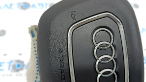 The Audi Q3 83A 19-25 steering wheel airbag is black, with peeling chrome and scratches.