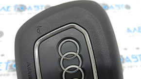 The Audi Q3 83A 19-25 steering wheel airbag is black, with peeling chrome and scratches.