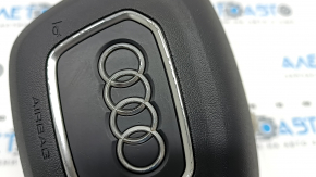 The Audi Q3 83A 19-25 steering wheel airbag is black, with peeling chrome and scratches.