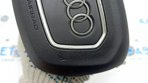 The Audi Q3 83A 19-25 steering wheel airbag is black, with peeling chrome and scratches.