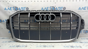 The Audi Q7 2020-2024 gray radiator grille assembly, with bracket and camera mount, is cracked and the chrome is peeling off.
