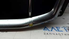 The Audi Q7 2020-2024 gray radiator grille assembly, with bracket and camera mount, is cracked and the chrome is peeling off.