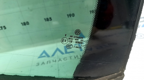 The rear left triangle door glass of a VW Tiguan 09-18 has a green tint and is broken.
