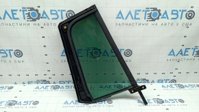 The rear left triangle door glass of a VW Tiguan 09-18 has a green tint and is broken.