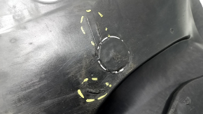The front left fender liner, lower part, BMW X7 G07 19-26, is dented and has tears.