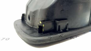 The fuel filler door housing of a Hyundai Sonata 11-15 has broken fasteners and a torn seal.