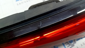 The right Mitsubishi Outlander 22-26 trunk door inner light has a cracked mount and scratches.