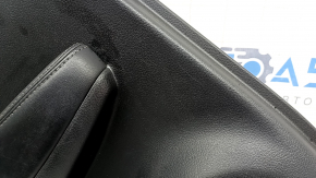 Rear left door panel for a 2022 Nissan Rogue Sport, black with black insert, black leather armrest, scratches