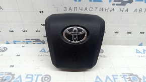 The airbag in the driver's steering wheel of a Toyota Prius 50 16-22 is black and scratched.