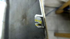 The bare lower rear bumper of a Volvo XC90 16-26 for parking sensors, white, the parking sensor mount is broken, dented, and there are cracks in the mounts.