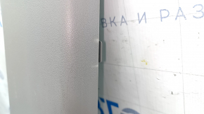 The lower right center pillar trim for a Toyota Prius V 15-17 is gray, worn, and the plastic has turned white.