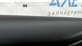 The front left door panel of a Chevrolet Volt 16 is black, with a black leather insert, the armrest is black leather, with a handle, without a trim and buttons, scratches