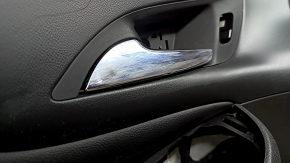 The front left door panel of a Chevrolet Volt 16 is black, with a black leather insert, the armrest is black leather, with a handle, without a trim and buttons, scratches