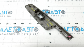 The rear right door window control panel for a Toyota Prius V 12-17 is gray and has some wear and scratches.