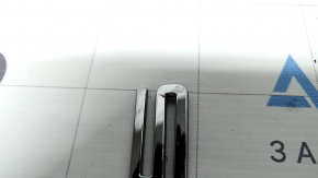 The "Porsche" emblem on the tailgate of a Porsche Macan 15-26 is cracked.