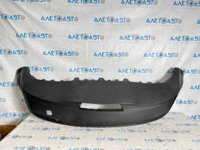 The bare lower rear bumper of the Tesla Model Y 20-25 is dented.
