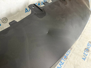The bare lower rear bumper of the Tesla Model Y 20-25 is dented.