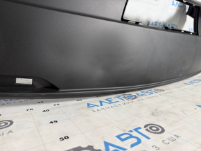 The bare lower rear bumper of the Tesla Model Y 20-25 is dented.