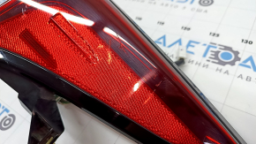 The upper right fender light of a Toyota Prius 50 19-22 is covered in glue and has scratches.