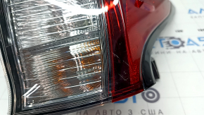 The upper right fender light of a Toyota Prius 50 19-22 is covered in glue and has scratches.