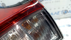 The upper right fender light of a Toyota Prius 50 19-22 is covered in glue and has scratches.