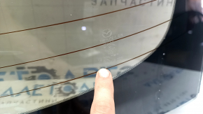 The rear window of a Mazda 3 19-26 4D Japan-built has bulged tint.