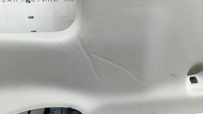 The headliner of a 20-22 Toyota Highlander is gray and has creases under the sunroof. The brackets have come loose and need cleaning.