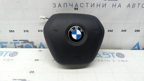 The airbag in the driver's steering wheel of the BMW 3 G20 19-26 is black and scratched.