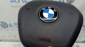 The airbag in the driver's steering wheel of the BMW 3 G20 19-26 is black and scratched.