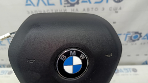The airbag in the driver's steering wheel of the BMW 3 G20 19-26 is black and scratched.