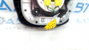 The driver's side airbag in the Jeep Compass 22-26 is black and has a rusty squib.