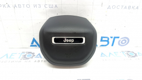 The driver's side airbag in the Jeep Compass 22-26 is black and has a rusty squib.