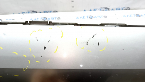 The bare lower rear bumper of a Volvo XC90 16-23, under the parking sensors and moldings, silver, scratches, chips, and blistered paint.