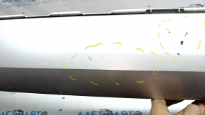 The bare lower rear bumper of a Volvo XC90 16-23, under the parking sensors and moldings, silver, scratches, chips, and blistered paint.